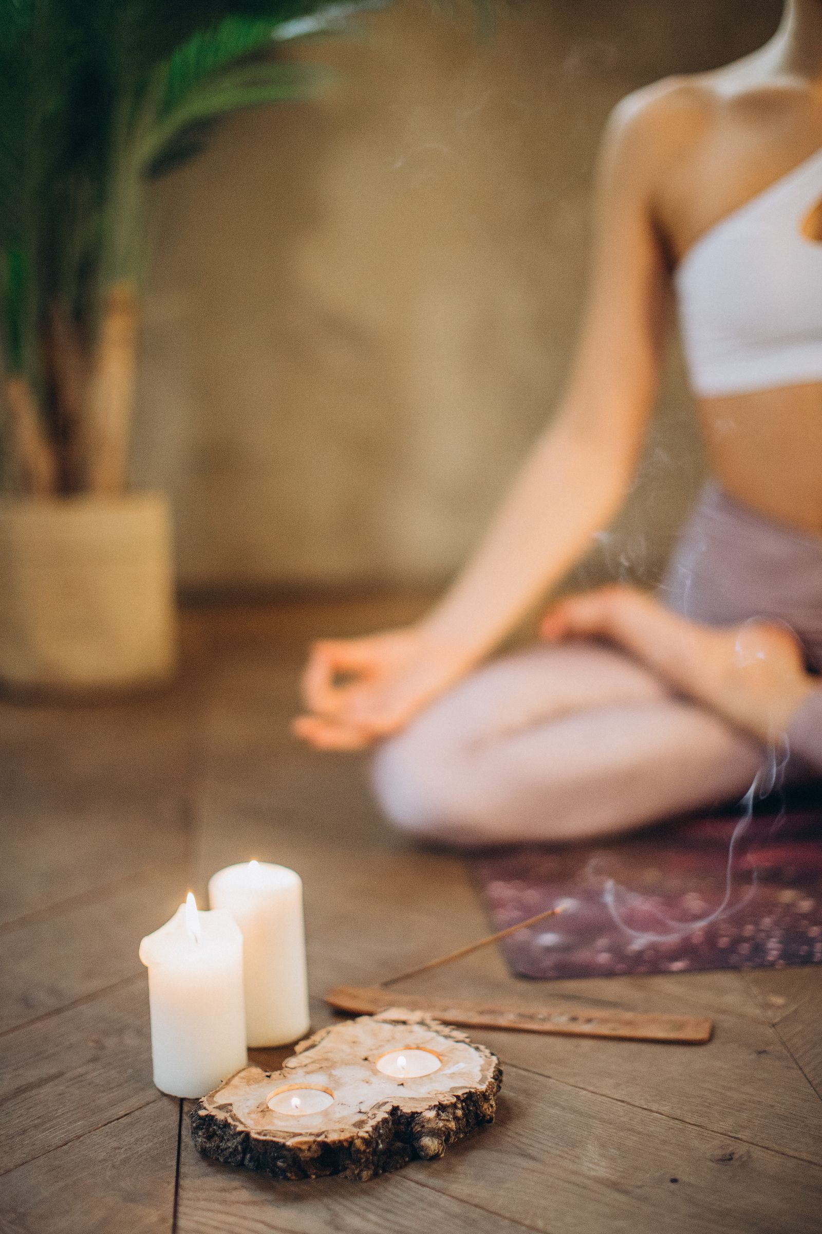 Une femme médite dans une lumière douce, entourée de bougies